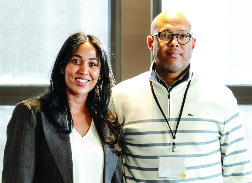 Two Optimus Health Care professionals smiling together at a Commure Nexus healthcare technology event